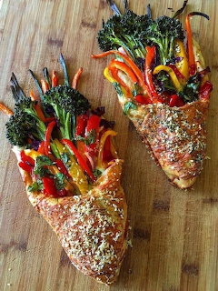 Two seeded bread slices topped with colorful roasted vegetables on wooden board
