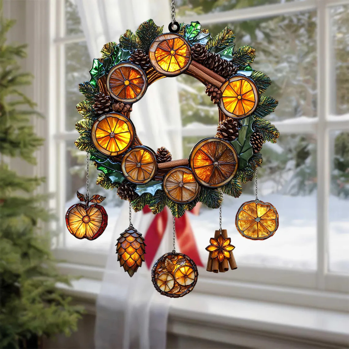 Christmas wreath with dried orange slices, pine cones, and ornaments hanging in a sunny window