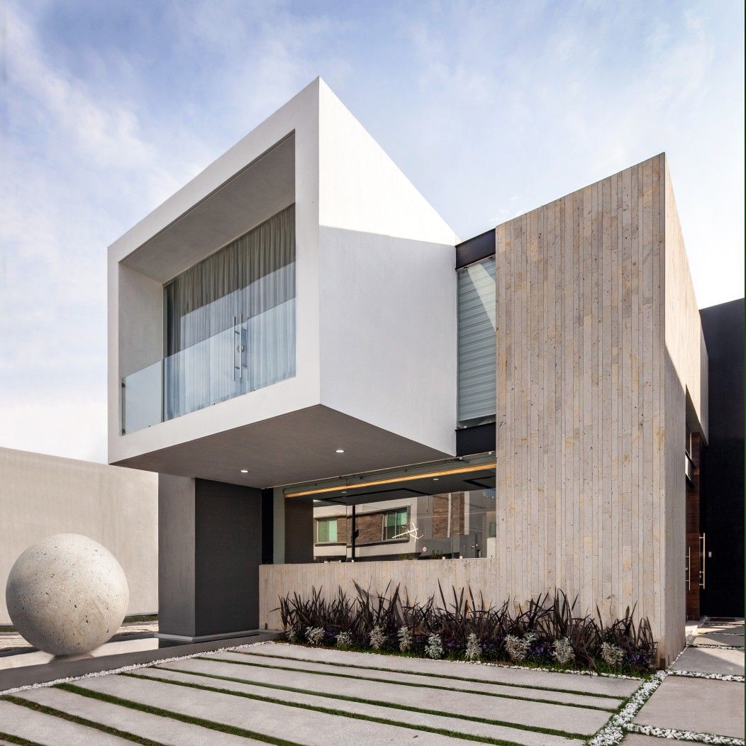Modern two-story house with white geometric facade, wood panel wall, and minimalist driveway