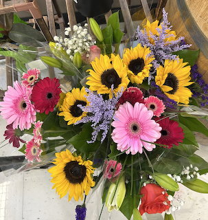 Colorful flower bouquet with sunflowers, pink gerbera daisies, and purple statice