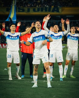 Universidad Católica soccer players celebrating on the field in white uniforms