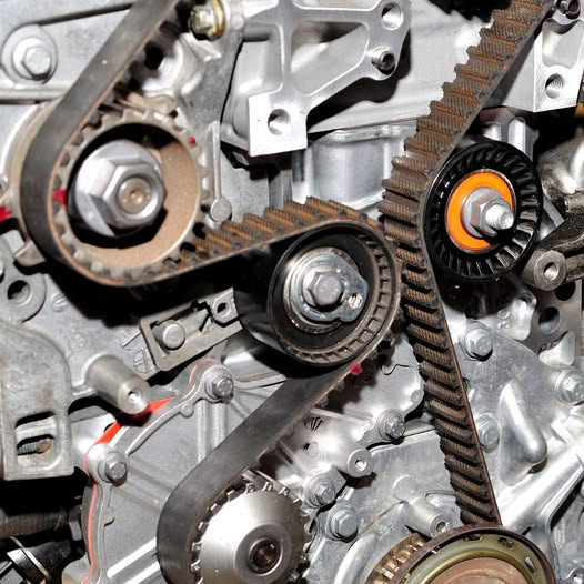 Close-up view of engine timing belt with pulleys and gears
