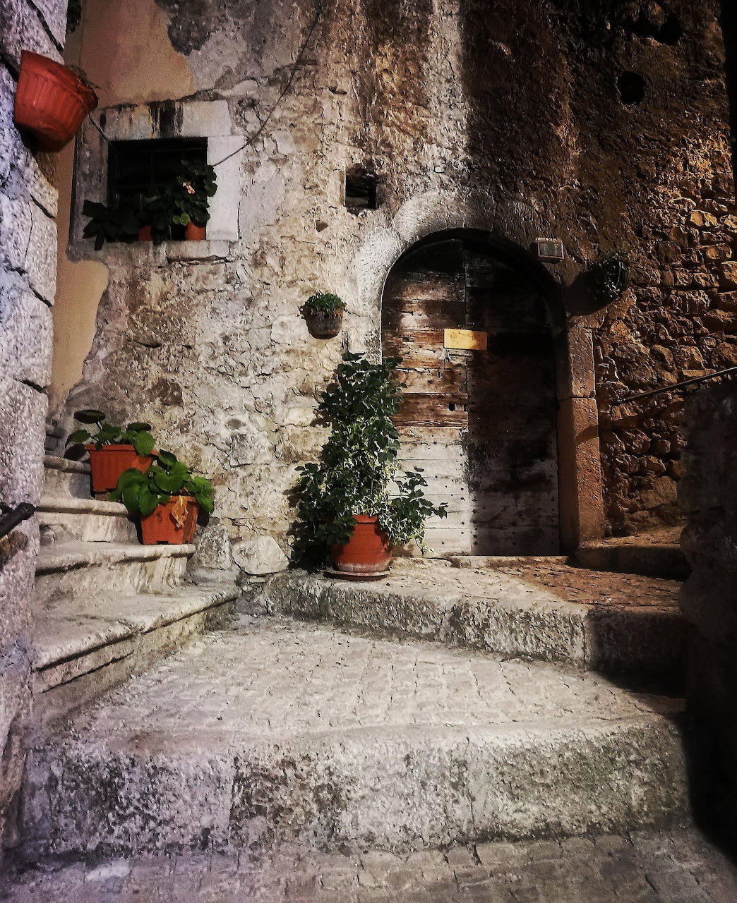 Narrow cobblestone alley in an Italian town with pastel buildings and hanging laundry