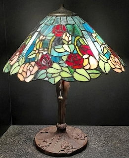 Colorful stained glass table lamp with floral shade on a dark background