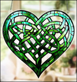 Green stained glass heart suncatcher with a Celtic knot pattern hanging by chains