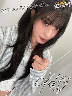 Young woman with long dark hair and bangs in a striped blouse taking a selfie