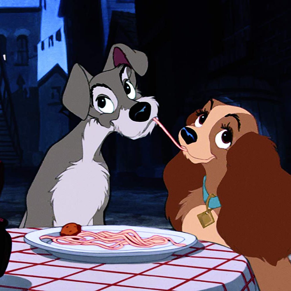 Lady and Tramp cartoon dogs sharing spaghetti at a table