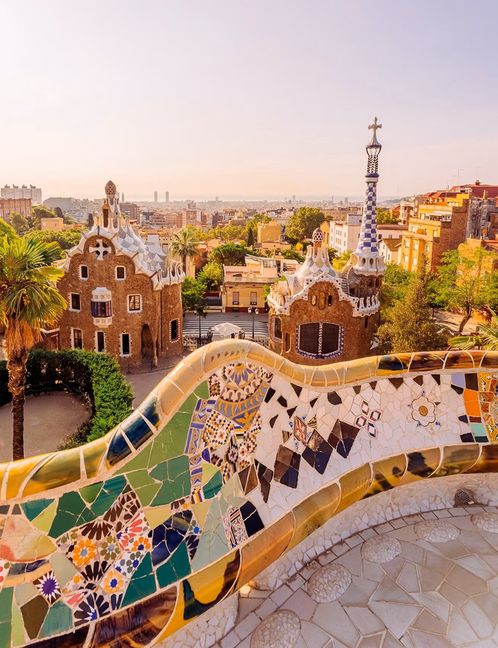 Colorful mosaic terrace at Park Güell in Barcelona with Gaudí architecture and city skyline