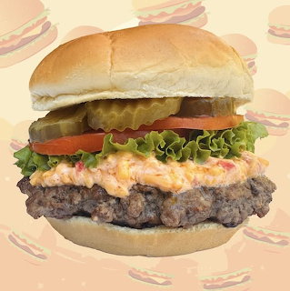 Close-up cheeseburger with lettuce, tomato, pickles, and a soft bun