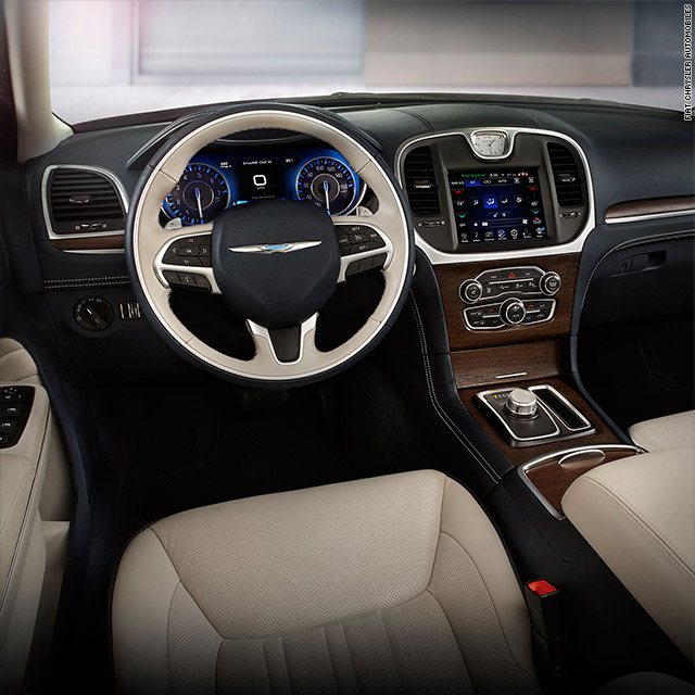 Luxury car interior with cream leather seats, wood trim dashboard, and digital touchscreen display