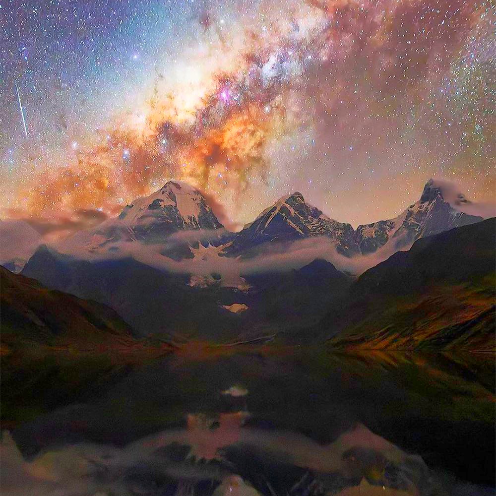 Milky Way galaxy stretching over mountain range with lake reflection at night
