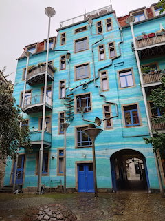 Blue facade with funnel-shaped drainpipe art at Kunsthofpassage in Dresden