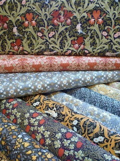 Stack of folded decorative fabrics with floral and paisley patterns in various colors