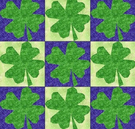 Quilt pattern with green shamrocks on cream and purple squares