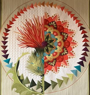 Abstract quilted mandala with floral, feather, and geometric patterns in a circular design
