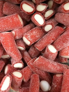 Close-up of red sugar-coated candies with white centers piled together