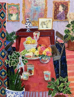Painted dining room interior with table laden with fruit and cheese, surrounded by plants and colorful artwork on walls