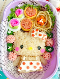 Hello Kity shaped rice bento box with decorative sausage roses, noodles, and colorful food art
