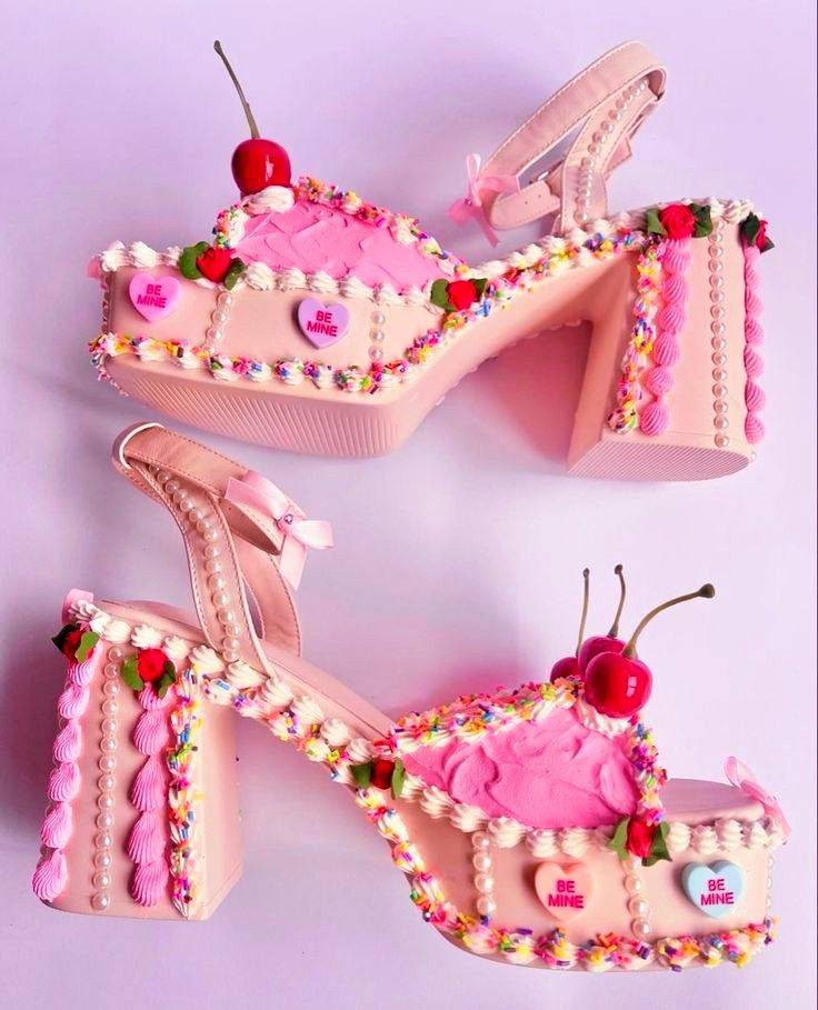 Pink platform sandals decorated with candy, cheries, and colorful bead embellishments on pink background