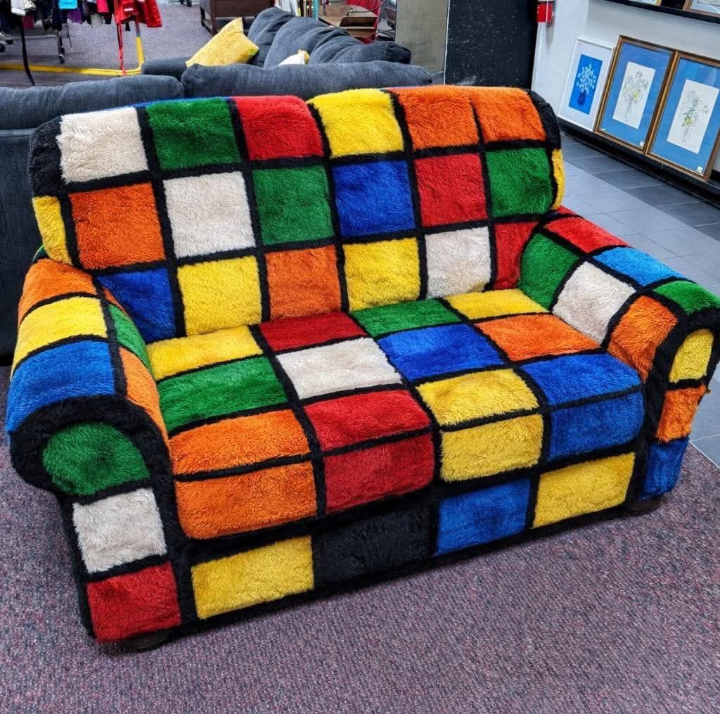 Plush sofa covered in multicolored squares resembling a Rubik's Cube pattern