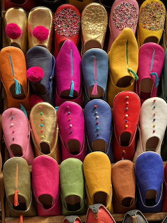 Rows of colorful Moroccan leather slippers arranged neatly for sale at a market