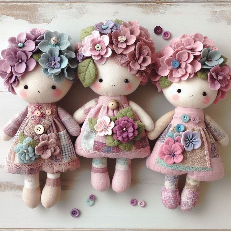 Three pastel rag dolls with flower crowns and floral dresses on a light background