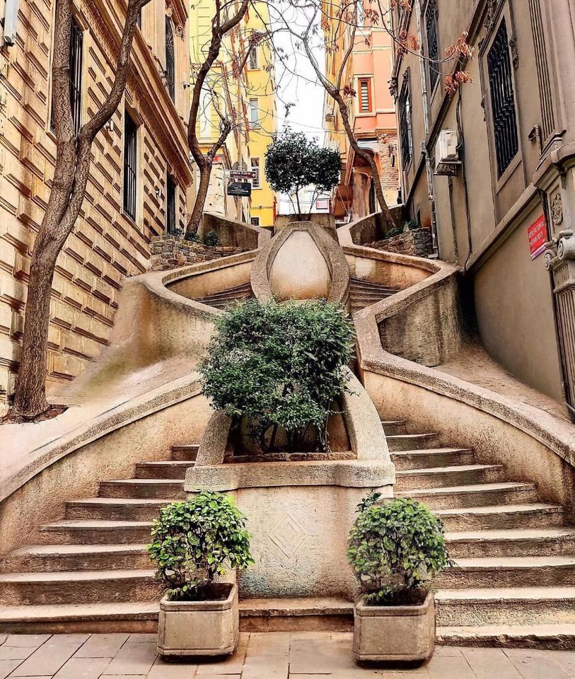Curved stone staircase with planters between historic buildings in Istanbul