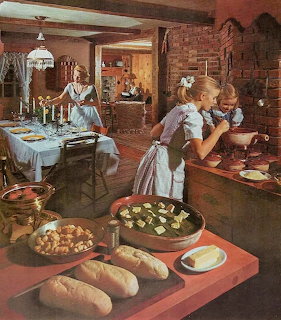 Mother and two daughters preparing dinner in a cozy vintage kitchen with bread and baked goods on counter