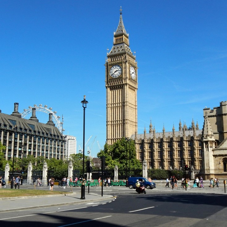 Big Ben clock tower and Palace of Westminster in London on a sunny day with people in the square