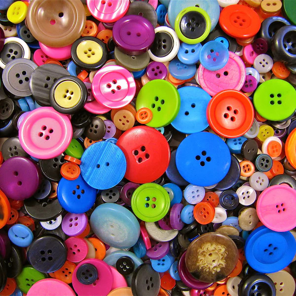 Dense pile of colorful sewing buttons in pink, blue, green, orange, purple, yellow, brown, and black