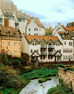 Dean Village historic buildings along river in Edinburgh with stone architecture and autumn foliage
