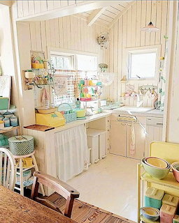Vintage pastel kitchen interior with retro cabinets, shelves, and ceramic dishware