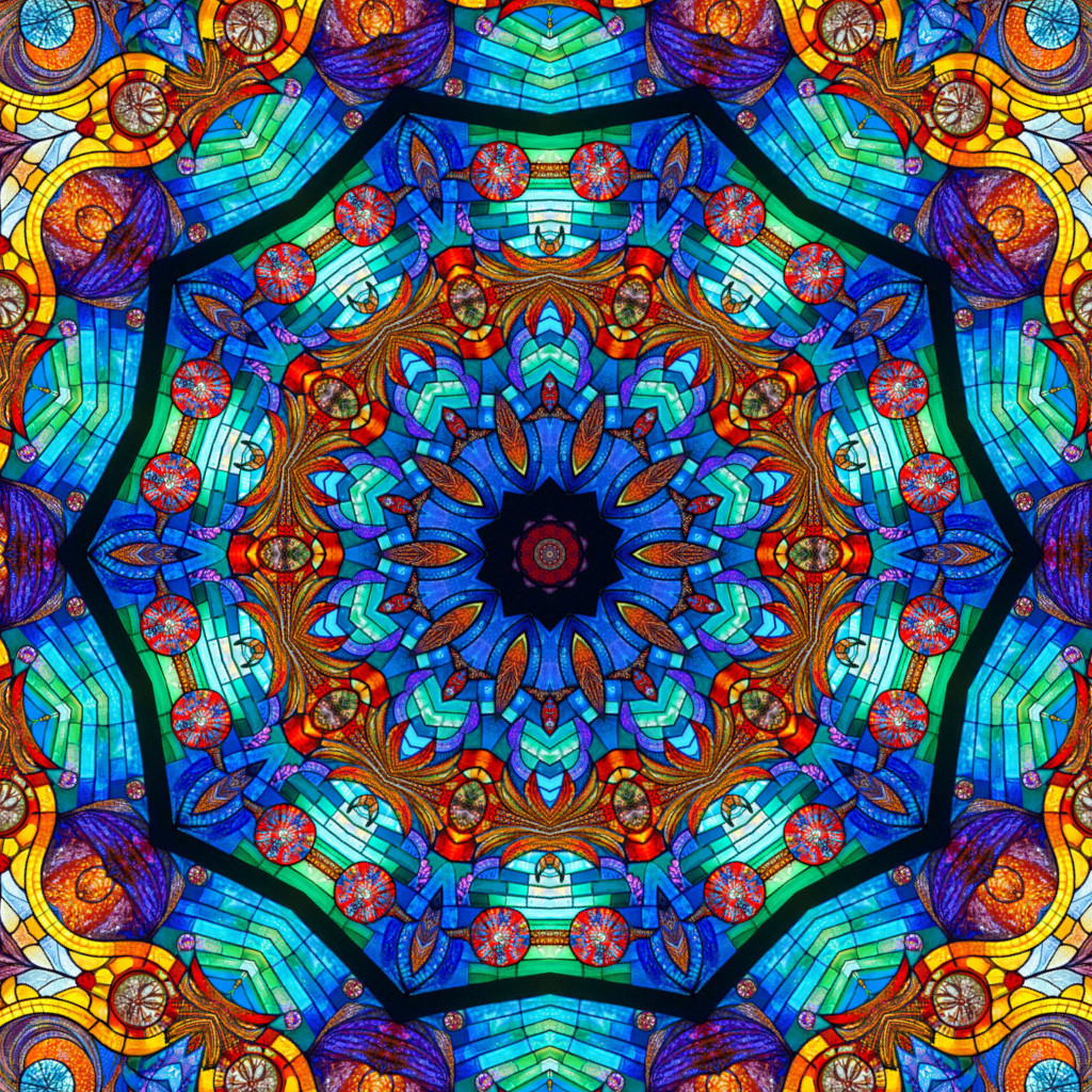 Colorful symmetrical mandala with blue, orange, and turquoise geometric patterns in radial design