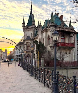 Gothic castle-like building in Košice with pointed towers and turquoise roof details at sunset