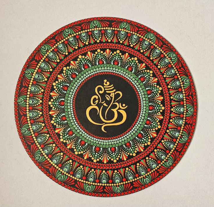 Ornate circular mandala with red, teal and gold geometric patterns and central golden symbol on beige background