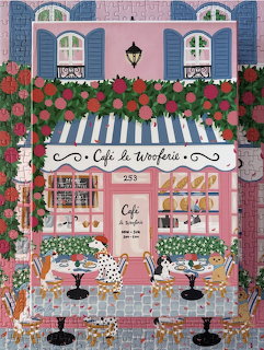 Illustrated pink French café with striped awning, outdoor tables, dogs, and lush flowers
