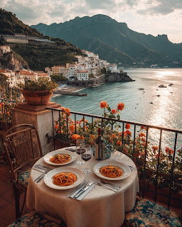 Pasta dishes on table with scenic Amalfi Coast view, hillside village and sea below