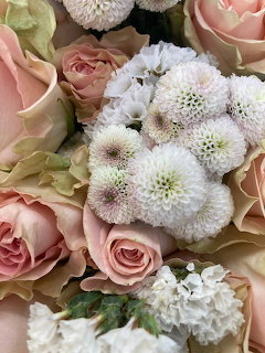 Close-up of pink roses and white pompon flowers in a bouquet