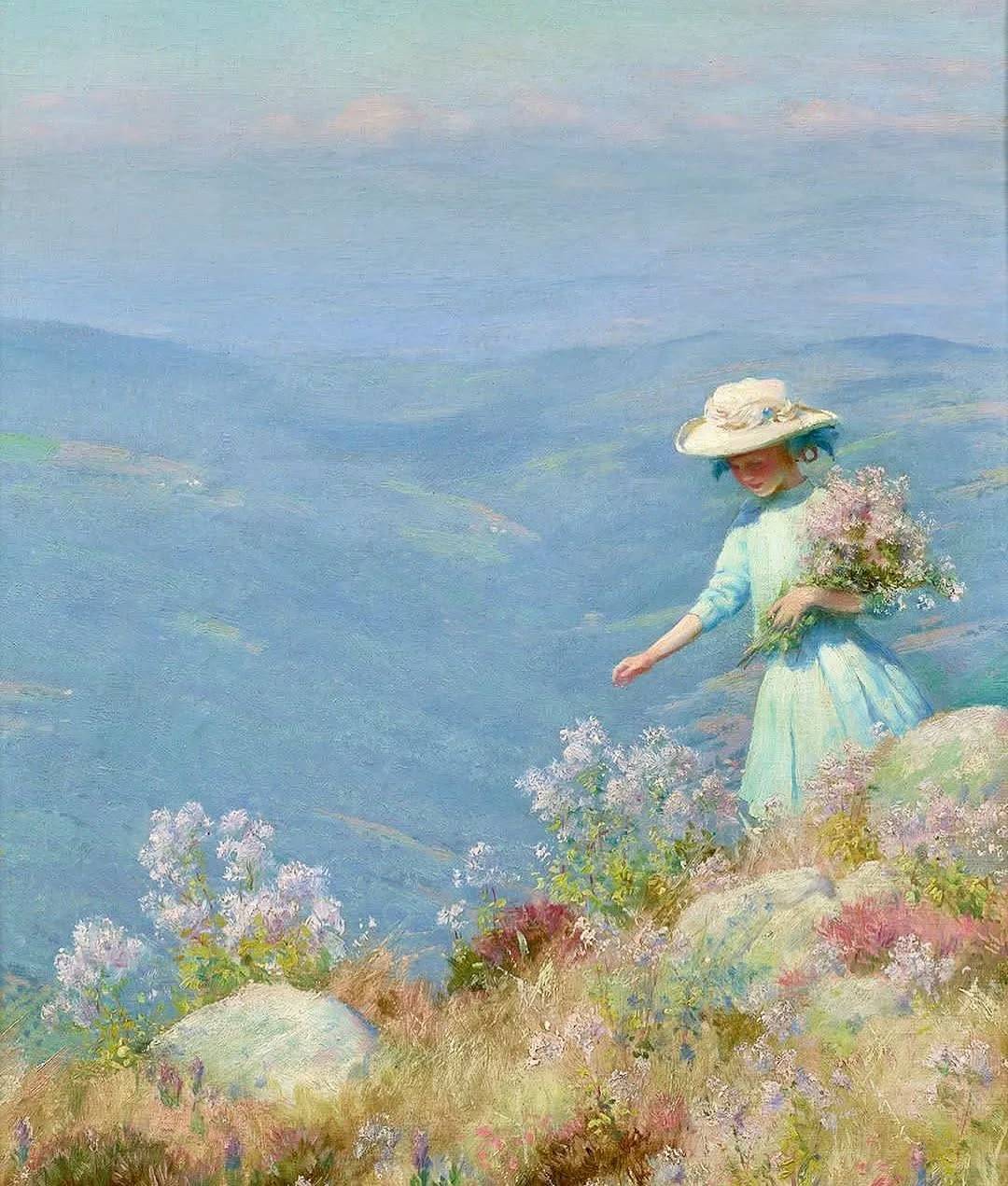 Woman in white dress picking flowers on a mountain slope with blue valleys below