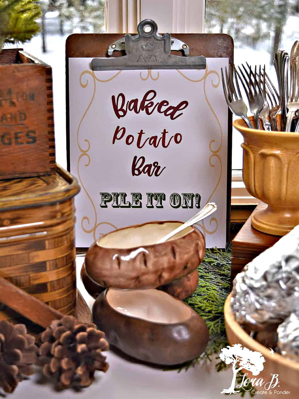 Baked potato bar sign surrounded by decorative potatoes, utensils and foil-wrapped potatoes.