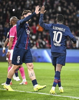 Two PSG football players high-fiving on the pitch, one wearing number 10 Dembélé jersey
