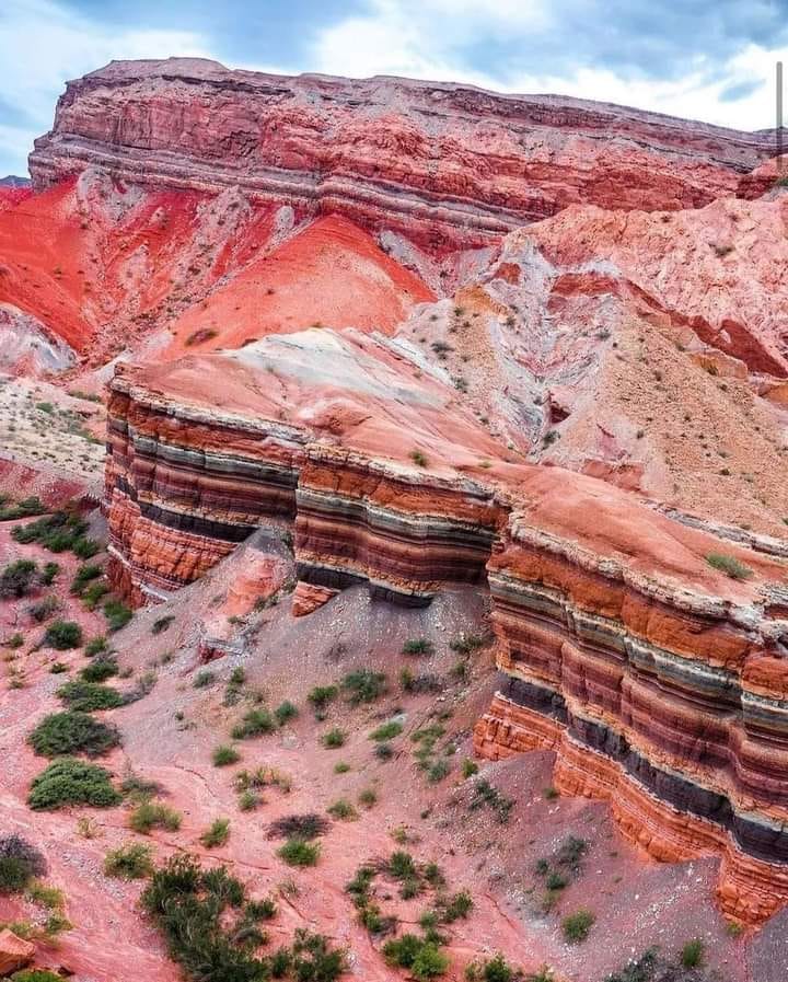 Layered red and ochre rock formations of La Yesera in Quebrada de las Conchas, Argentina.