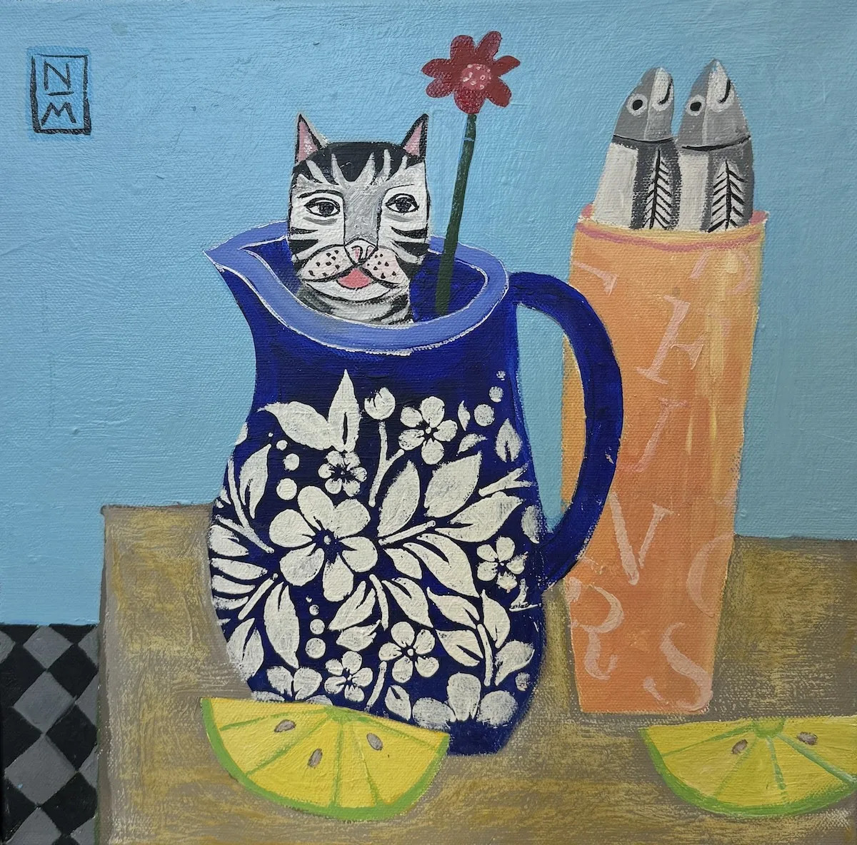 Gray tabby kitten sitting in ornate blue pitcher with white flowers, lemon slices and decorative vase nearby