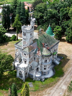 Aerial view of Castello de Dona Chica, a Neo-Gothic castle with towers and green roof in Braga, Portugal