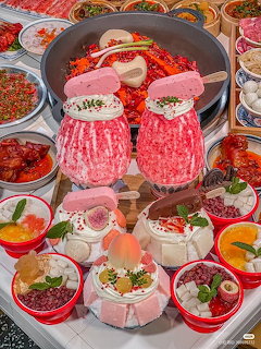 Elaborate Chinese hot pot setup with rose-shaped sliced beef, side dishes, and spicy red broth