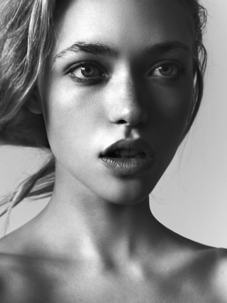 Black-and-white close-up portrait of a woman gazing toward the camera.