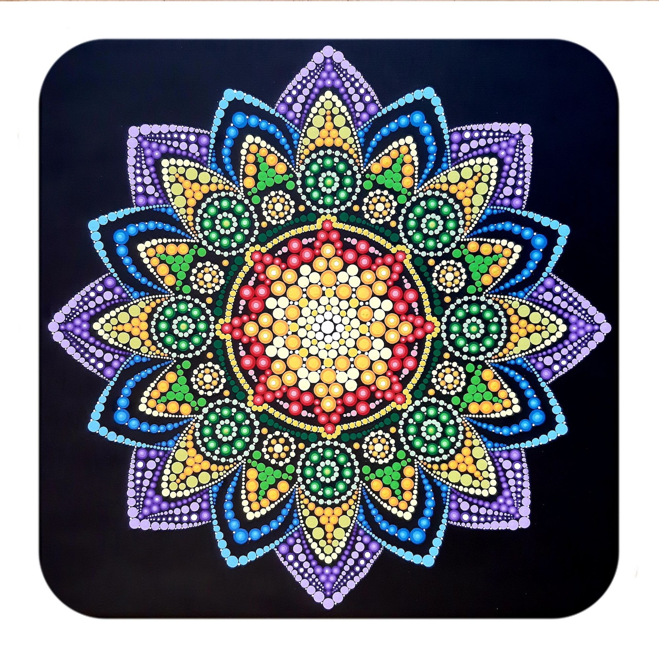 Colorful mandala with symmetrical dotted petals in purple, blue, yellow, and red on black background