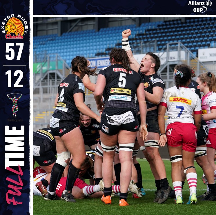 Rugby team in black uniforms celebrating victory with raised fist, scoreboard showing 57-12