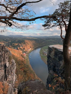 Aerial view from sandstone cliffs of Elbe River curving through autumn-colored Saxon Switzerland landscape