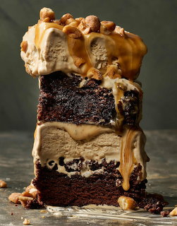 Stack of chocolate cake slices with caramel sauce and pecans dripping down the sides